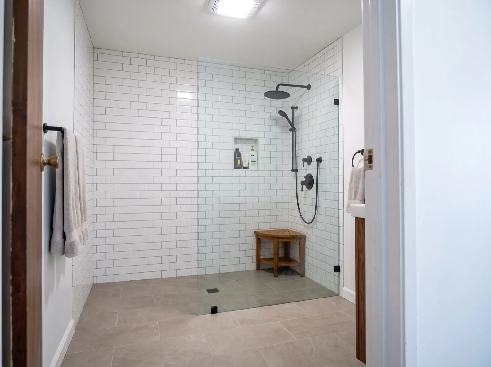 Tub-to-shower conversion with white subway tile and glass panel